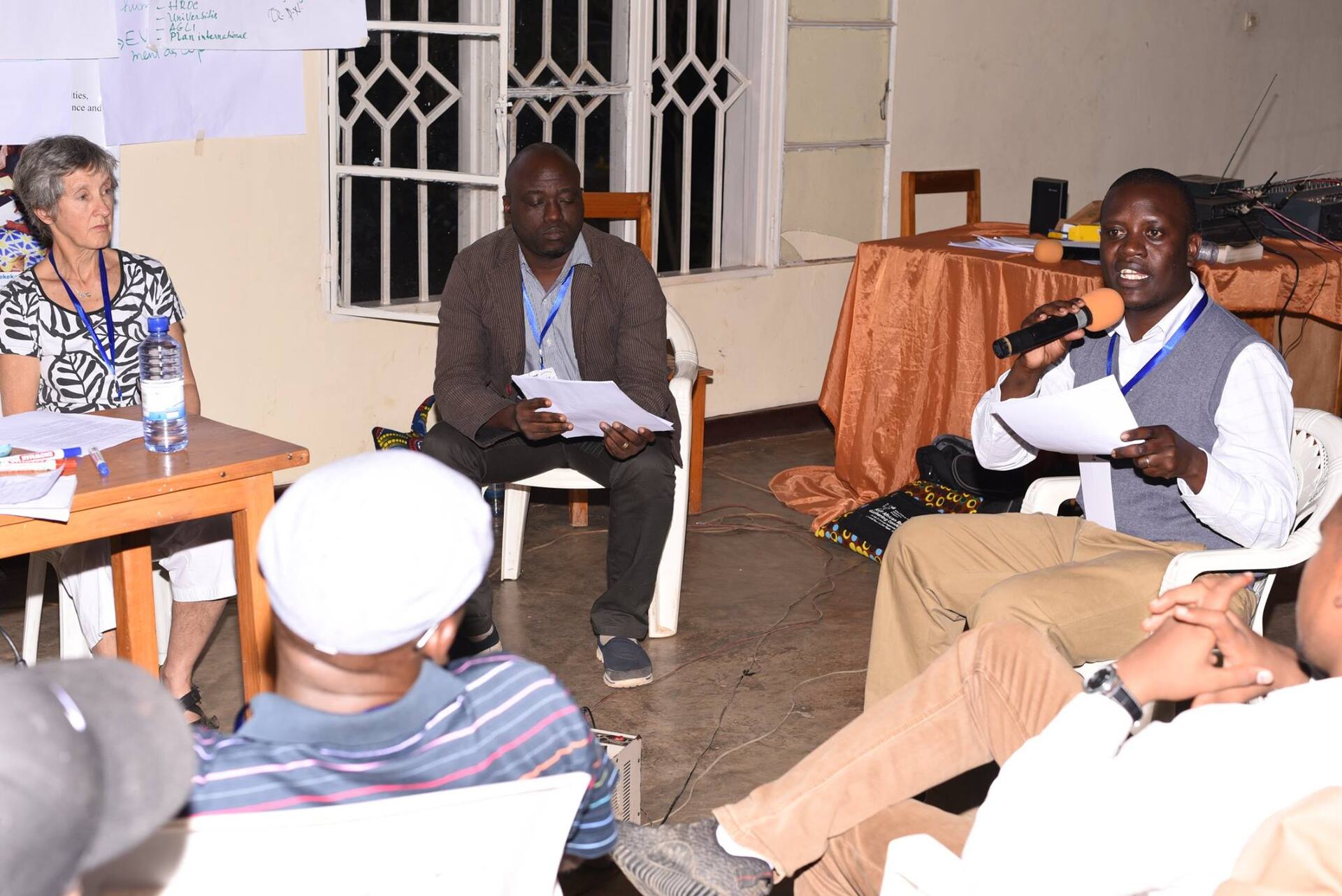 A participant speaks into a microphone during a facilitated community meeting